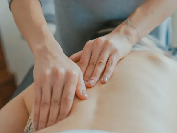 Kinesitherapeut helpt patiënt met oefeningen